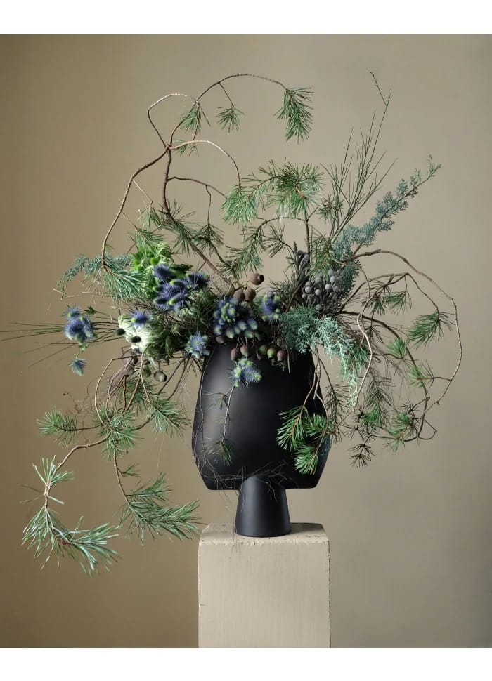 «Sculptural botanical arrangement σε μαύρο βάζο — φυσικά κλαδιά, χειμερινή πρασινάδα και καλλιτεχνική σύνθεση σε editorial ύφος»